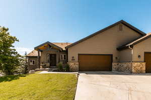 View of front of property featuring a garage and a front yard