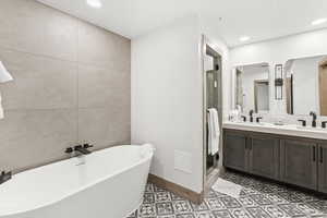 Bathroom featuring vanity, tile patterned floors, and plus walk in shower