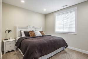 Bedroom featuring light carpet