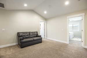 Living area with lofted ceiling and carpet