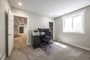 Carpeted office featuring a textured ceiling