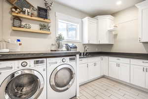 Laundry area with cabinets, washer and dryer, and sink