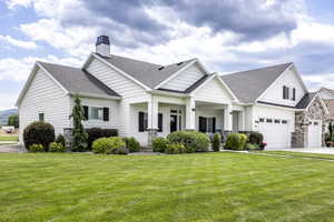 View of front of house featuring a garage, a front yard, and a porch