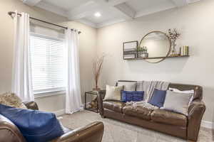 Living room with coffered ceiling, beamed ceiling, and carpet