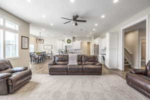 Living room with ceiling fan, sink, and light wood-type flooring