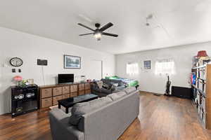 Living room with dark hardwood / wood-style flooring and ceiling fan