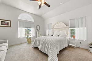 Carpeted bedroom with multiple windows, a textured ceiling, high vaulted ceiling, and ceiling fan