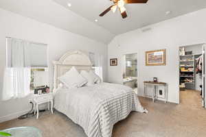 Carpeted bedroom with vaulted ceiling, connected bathroom, a spacious closet, ceiling fan, and a closet