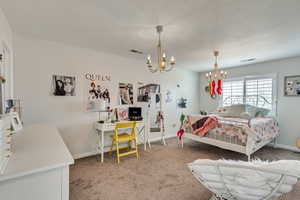 Bedroom featuring a chandelier and dark colored carpet