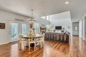 Dining space with an inviting chandelier, hardwood / wood-style floors, and a textured ceiling