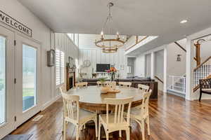 Dining area with wood-type flooring, a textured ceiling, and an inviting chandelier