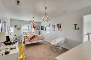 Bedroom featuring carpet and an inviting chandelier