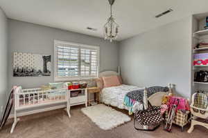 Carpeted bedroom with a chandelier