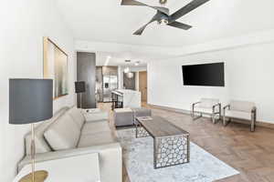 Living room featuring ceiling fan and light parquet floors