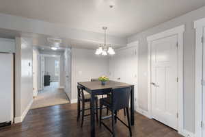 Dining area featuring dark hardwood / wood-style flooring and a chandelier