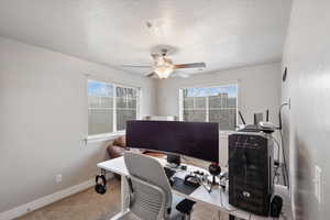 Office area featuring ceiling fan and a textured ceiling