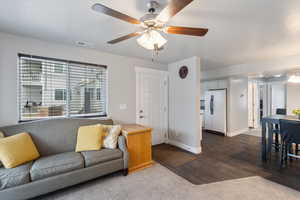 Carpeted living room with ceiling fan