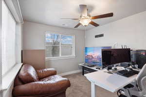 Carpeted office featuring ceiling fan