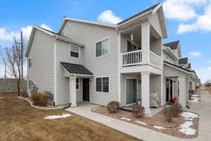 View of front of property featuring a front lawn and a balcony