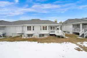 Rear view of covered deck with stairs to gorgeously landscaped community