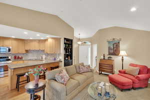 Open kitchen/living room featuring vaulted ceiling