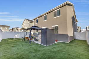 Rear view of property featuring a gazebo and a lawn