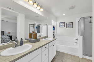 Bathroom featuring independent shower and bath, vanity, and tile patterned floors