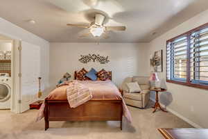 Carpeted bedroom featuring ceiling fan and washer / clothes dryer