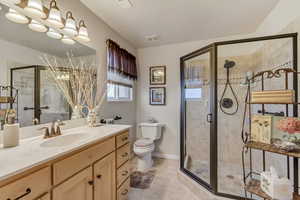 Bathroom with tile patterned flooring, vanity, an enclosed shower, and toilet