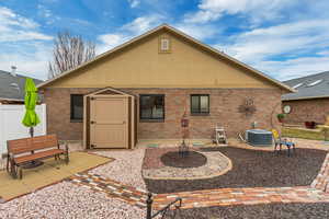 Back of house with a shed, central AC unit, and a patio area