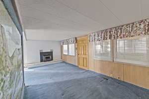 Unfurnished living room with wooden walls and carpet floors