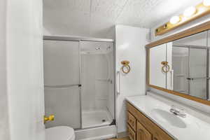 Bathroom with vanity, toilet, and a shower with door