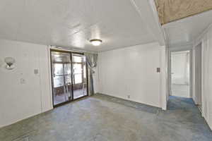 Carpeted empty room featuring a textured ceiling