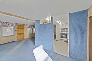 Interior space featuring wooden walls and a textured ceiling