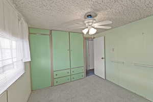 Unfurnished bedroom with ceiling fan and light colored carpet