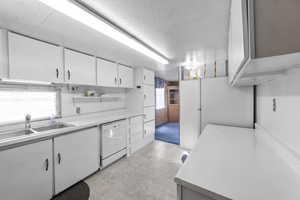 Kitchen with sink, white cabinets, and dishwasher