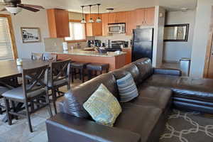 Living room with sink, light tile patterned floors, a textured ceiling, and ceiling fan