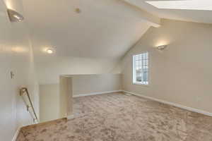 Bonus room featuring vaulted ceiling and carpet flooring