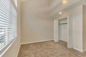 Unfurnished bedroom with light carpet and a closet