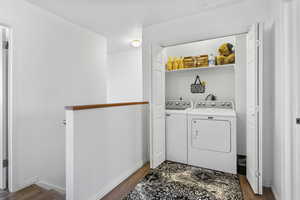 Laundry area with dark hardwood / wood-style flooring and washer and clothes dryer