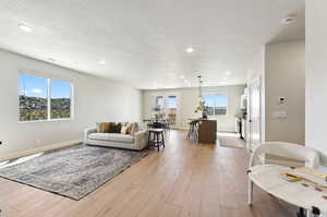 Living room featuring french doors, light hardwood / wood-style flooring, and a textured ceiling