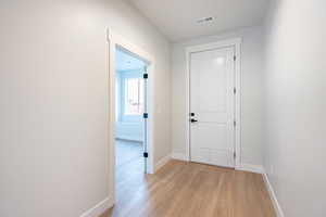 Hallway featuring light waterproof luxury vinyl plank flooring