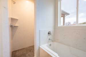 Primary Bathroom featuring shower with separate bathtub with full surround quartz walls