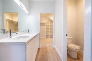 Primary Bathroom featuring light waterproof luxury vinyl plank flooring, and quartz double vanity