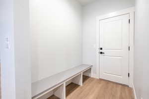 Mudroom entry from garage with light waterproof luxury vinyl plank flooring and quartz top bench seat