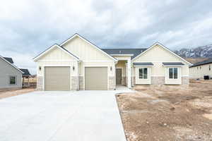 View of front of home with cooling unit, a mountain view, and a garage