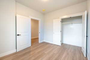 Bedroom 1 featuring a closet and light waterproof luxury vinyl plank flooring