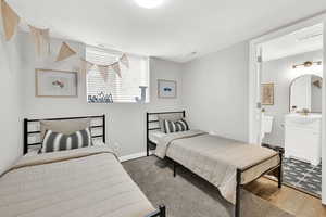 Bedroom featuring hardwood / wood-style flooring, sink, and ensuite bath