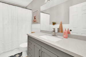 Bathroom with tile patterned floors, vanity, and toilet