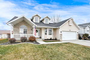 View of front of home featuring a garage, a front yard, and covered porch